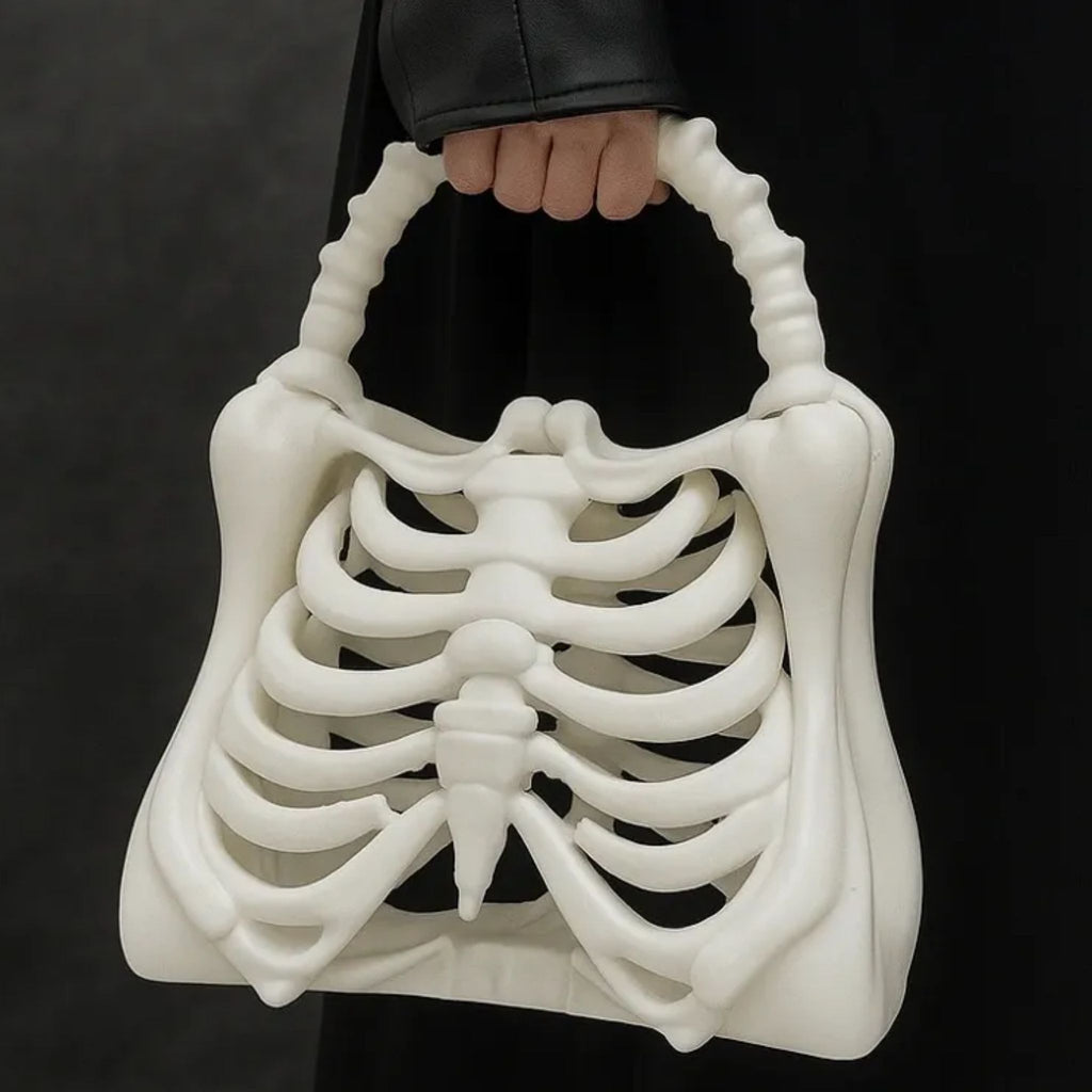 White skeleton handbag held by a person against a black background