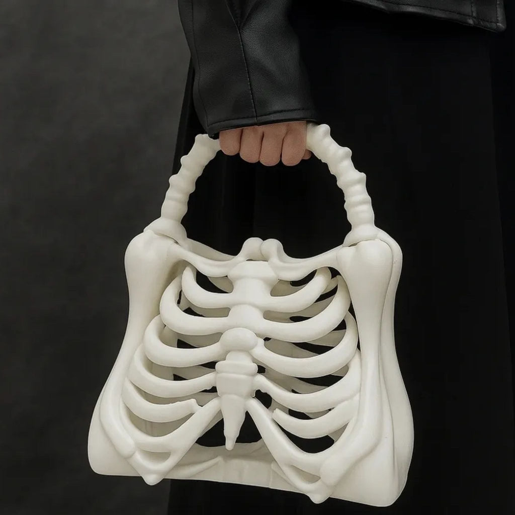 White skeleton handbag held by a person against a dark background